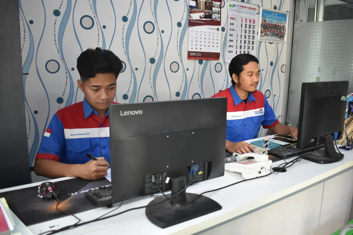 Staf Percetakan Ivorie mencatat spesifikasi pesanan cetak di komputer