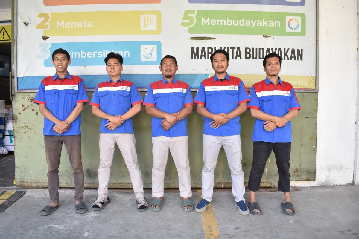 Tim customer service dan manajemen Percetakan Ivorie berseragam biru
